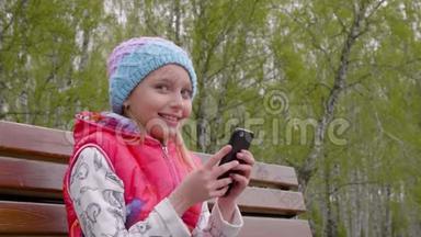 <strong>春城</strong>公园坐在长椅上玩智能手机的青少年女孩